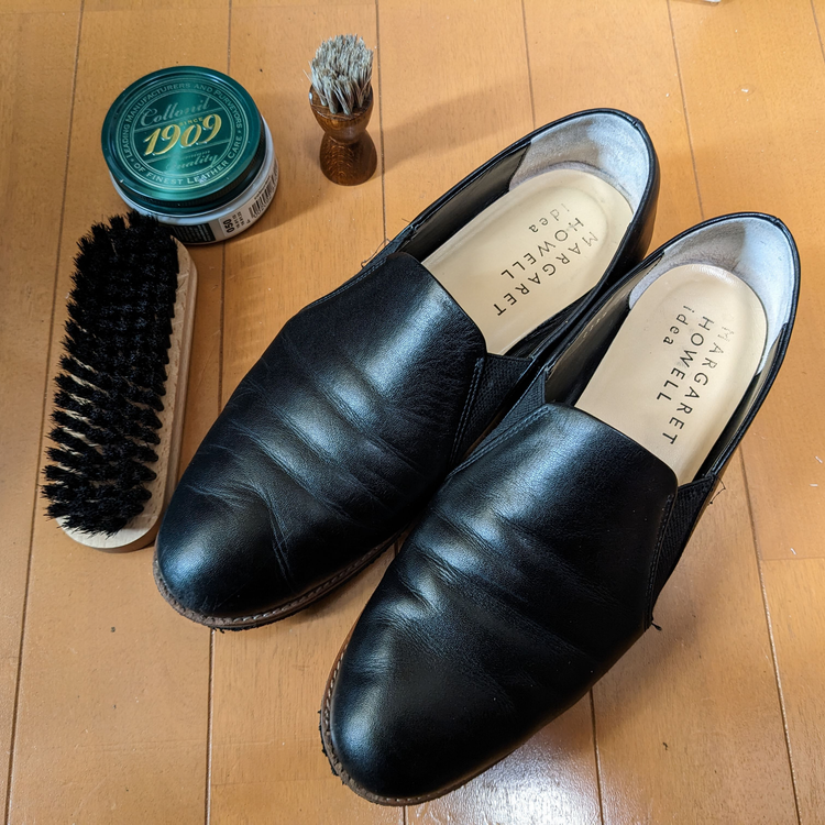 マーガレットハウエルアイデアのカッターシューズ、1909のクリームを塗って豚毛のブラシで磨いたところと、豚毛のブラシと1909クリームの容器とペネトレイトブラシが一緒に写っている