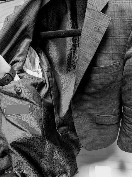 スーツのジャケットの写真。右側の内ポケットに手を突っ込んでいる。