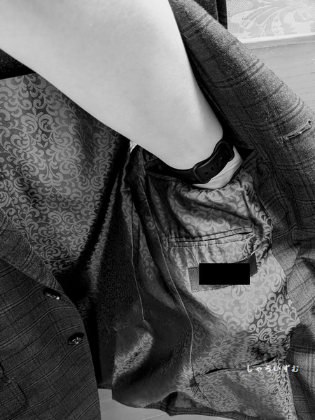 スーツのジャケットの写真。
左側の内側の内ポケットに手を突っ込んでいる。
その下にも、ペンポケットとタバコポケットがあり、左側だけで合計3つのポケットが内側についている。